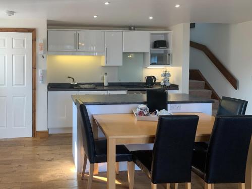a kitchen and dining room with a table and chairs at Granary in North Somercotes