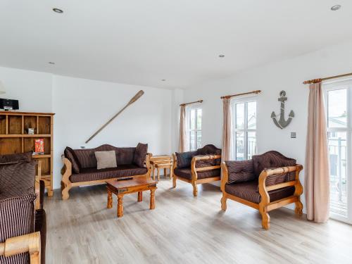a living room with wooden furniture and windows at Spinaker-18149 in Wroxham