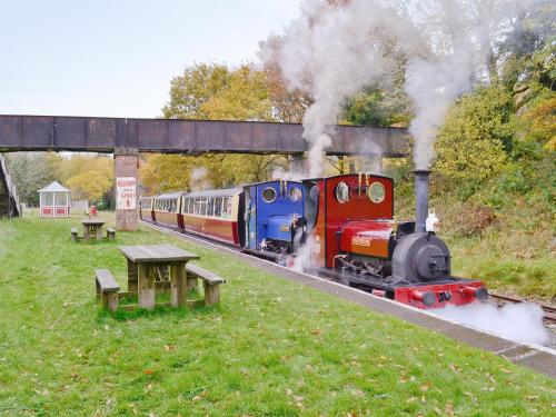 a train traveling down the tracks with smoke at Glampio Tryso Garth-Ukc5827 in Llangwm