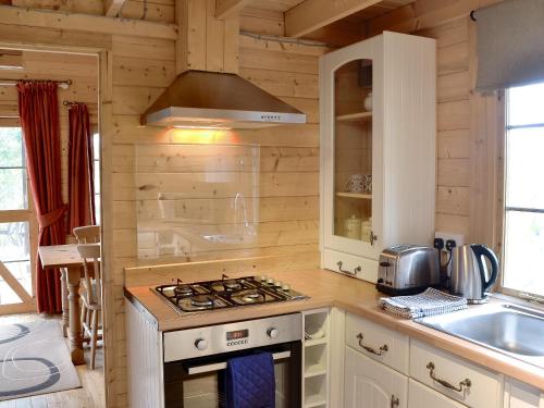 a kitchen with a stove and a sink at Forest Lodge in Godshill
