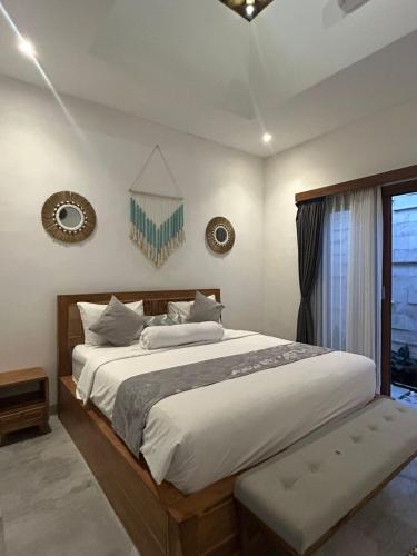 a bedroom with a large bed and a window at Amy Guesthouse Nusa Dua in Nusa Dua
