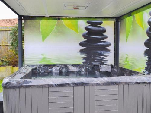 a bath tub with a painting of a stack of rocks at Corner House in Cromer