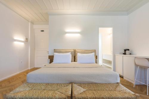 a bedroom with a large bed with white walls at Guesthouse Niriides in Spetses