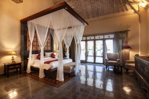 a bedroom with a canopy bed in a room at Sunset Paradise Villa Nusa Dua in Nusa Dua