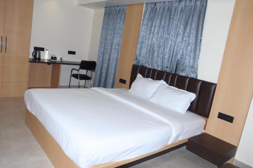 a bedroom with a large white bed with a window at Fern Inn Hotel in Kolkata