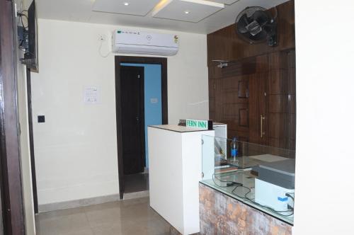 a kitchen with a white refrigerator in a room at Fern Inn Hotel in Kolkata