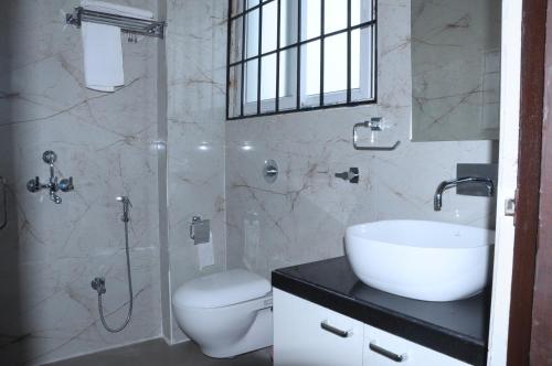 a bathroom with a sink and a toilet and a shower at Fern Inn Hotel in Kolkata