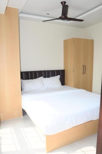 a bedroom with a large bed and a wooden cabinet at Fern Inn Hotel in Kolkata