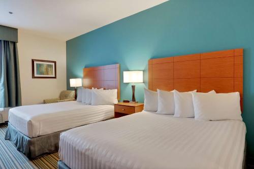 a hotel room with two beds and a blue wall at Best Western Liberty Inn DuPont JBLM in DuPont