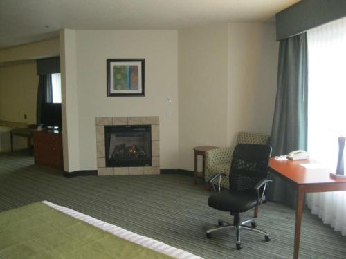 a room with a fireplace and a desk and a chair at Best Western Liberty Inn DuPont JBLM in DuPont