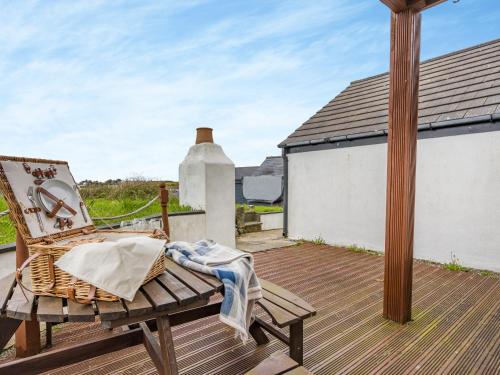 a rocking chair on a wooden deck with a house at Ben Ma Cree in Portpatrick