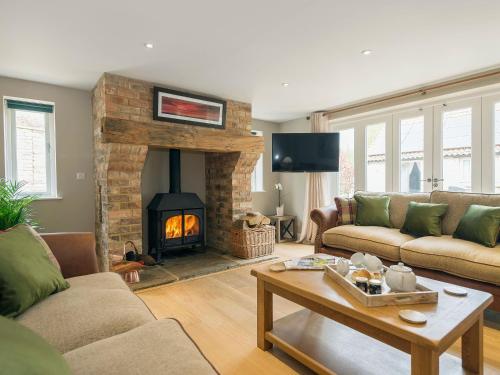 a living room with a fireplace and a couch at The Stables in Heydour