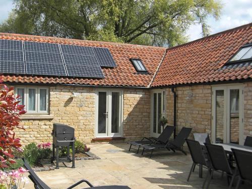a patio with chairs and solar panels on a house at The Stables in Heydour
