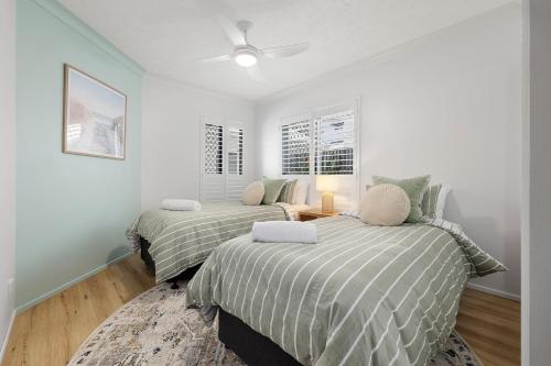 a bedroom with two beds and a ceiling fan at Sunrise Cove 9 - Creekfront on Cudgen Creek in Kingscliff