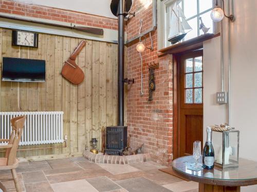 Habitación con pared de ladrillo y estufa de leña. en The Shieling, en Freshwater
