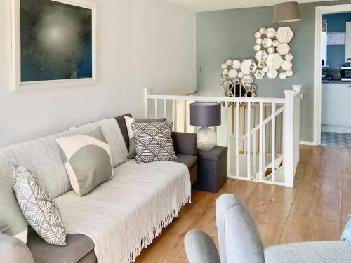 a living room with a couch and a chair at Corner View in Broadstairs