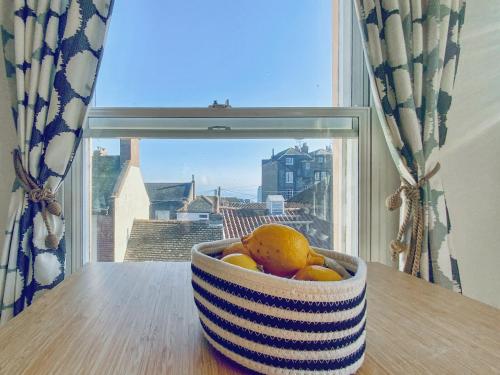 a bowl of fruit sitting on a table in front of a window at Corner View in Broadstairs