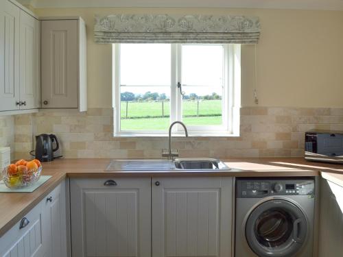 a kitchen with a sink and a washing machine at The Old Bull Pen in Appleshaw