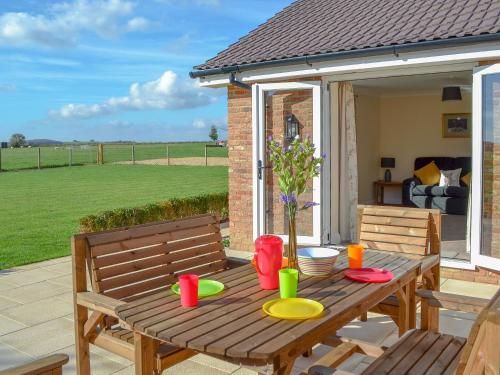 a wooden table and chairs on a patio at The Old Bull Pen in Appleshaw
