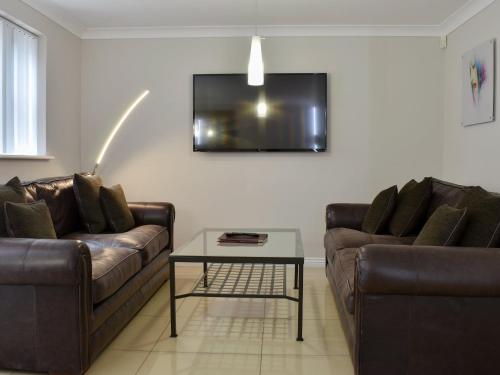 a living room with two leather couches and a table at Hollies Cottage 10- Ukc4536 in Martock