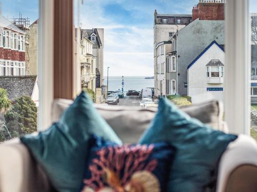 a couch sitting in a window with a view of the ocean at Dyma Y Bywyd in Tenby