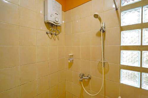 a shower with a shower head in a bathroom at Hotel O 92453 '139 Guest House in Bojongsoang
