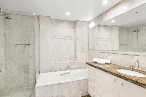 a bathroom with a tub and a sink and a shower at Spectacular Suite, Bridge & Water views, The Rocks in Sydney
