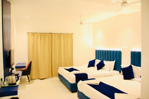 a hotel room with two beds and a desk at Brigade Hotels and Resorts in Srikalahasti