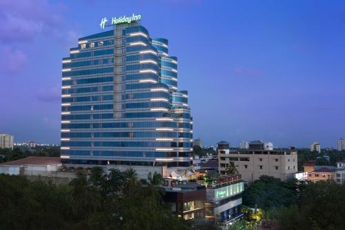 a tall building with a sign on top of it at Holiday Inn Cochin by IHG in Cochin