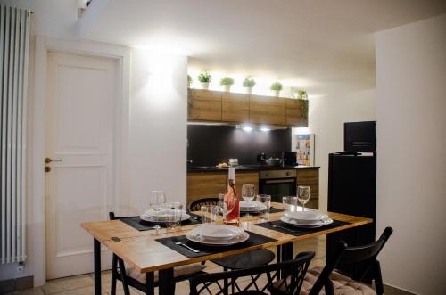 a dining room table with glasses and a bottle of wine at Maison de l'aiR - apt with Jacuzzi in Giovinazzo