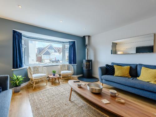 a living room with a blue couch and a table at Ocean Beach in Felpham