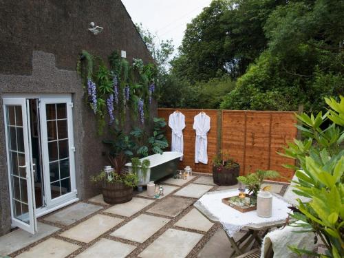 a garden with a bath tub and potted plants at Rose Blair Lodge - Uk31045 in Portpatrick