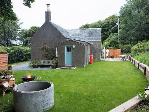 a small house with a yard with a fire pit at Rose Blair Lodge - Uk31045 in Portpatrick