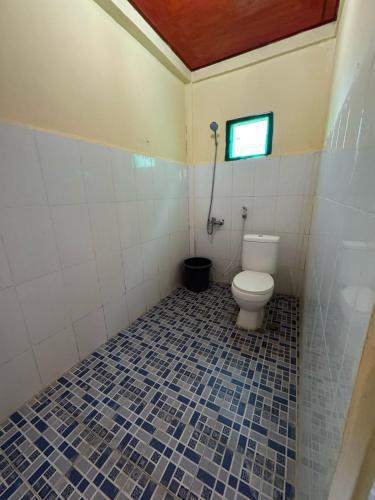 a bathroom with a toilet and a window at Aman's Guesthouse in Tuk Tuk