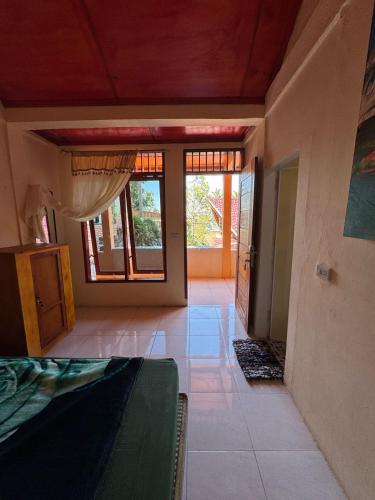 a living room with a bed and a room with windows at Aman's Guesthouse in Tuk Tuk