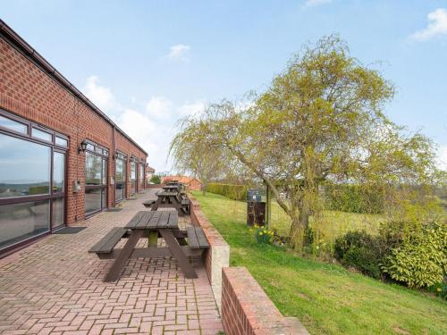 a group of picnic tables sitting on a brick sidewalk at Cottage 9 - Uk38220 in Ashby cum Fenby