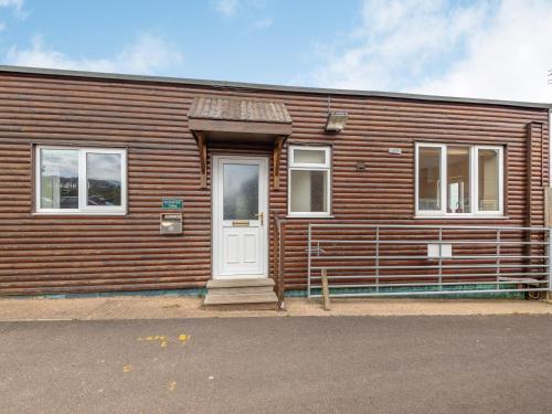 a wooden building with a white door and windows at Country View - Uk38223 in Ashby cum Fenby