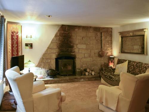 un salon avec un canapé et une cheminée dans l'établissement Keeper's Cottage, à Crowborough