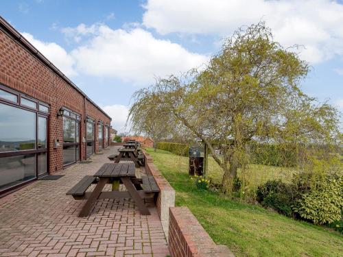 a group of picnic tables next to a brick building at Cottage 7 - Uk38218 in Ashby cum Fenby