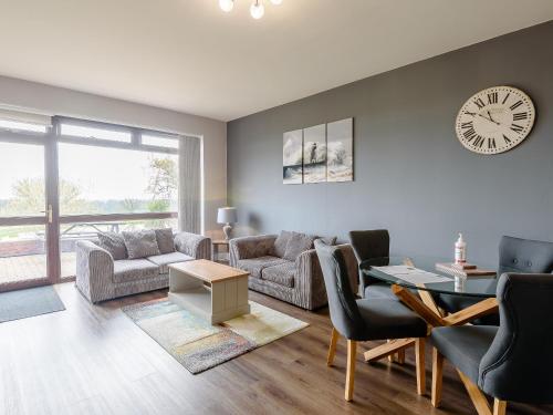 a living room with a couch and a clock on the wall at Cottage 7 - Uk38218 in Ashby cum Fenby