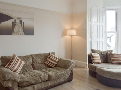 una sala de estar con un sofá y una silla en Charlotte Street, en Ayr