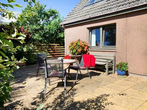 a patio with a table and chairs and a bench at Sheildaig Cottage Annex in Laurencekirk