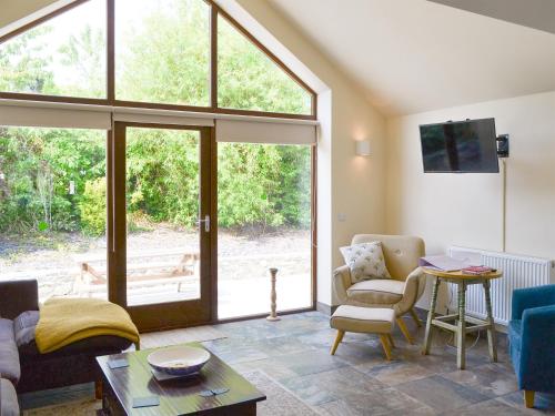 a living room with a couch and chairs and a window at Lili Wen in Llanfachraeth