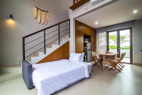 a bedroom with a large white bed and a table at Nusa Djiwa in Tanah Lot