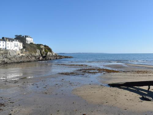 a sandy beach with houses and the ocean at Seatons Rest in Portmellon