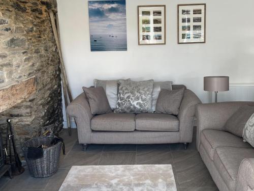 a living room with a couch and a chair at Seatons Rest in Portmellon