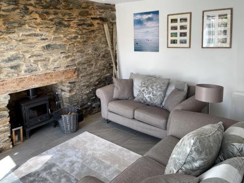 a living room with a couch and a fireplace at Seatons Rest in Portmellon