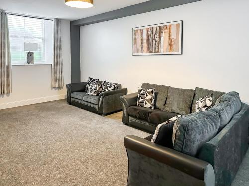 a living room with a couch and two chairs at The Old School House in Eggleston