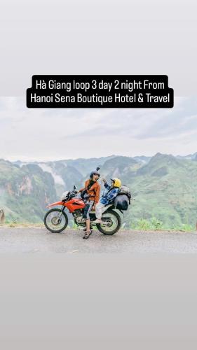 a man sitting on a motorcycle on the road at Sena Boutique Hotel & Travel in Hanoi