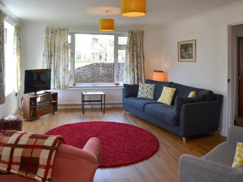 a living room with a couch and a red rug at The Bungalow in Topsham